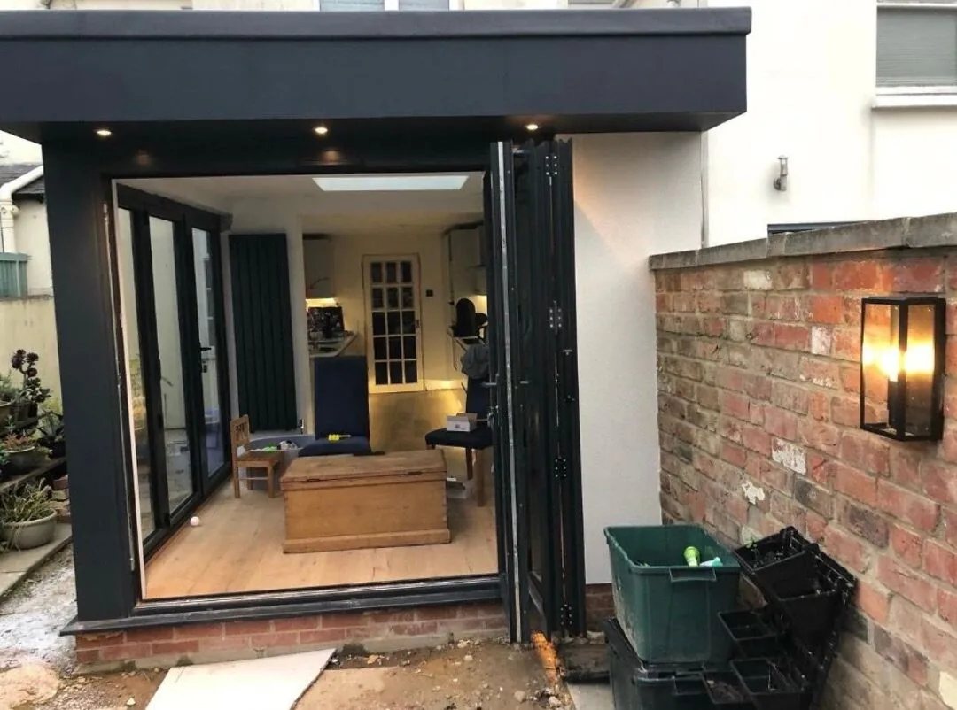 Soffit downlights and an outdoor wall lantern lit on the rear elevation of a single storey extension